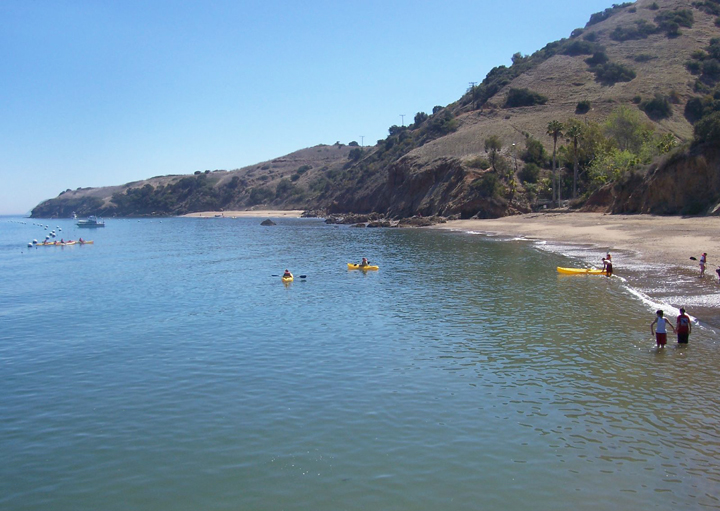 kayakers near hilly shoreline