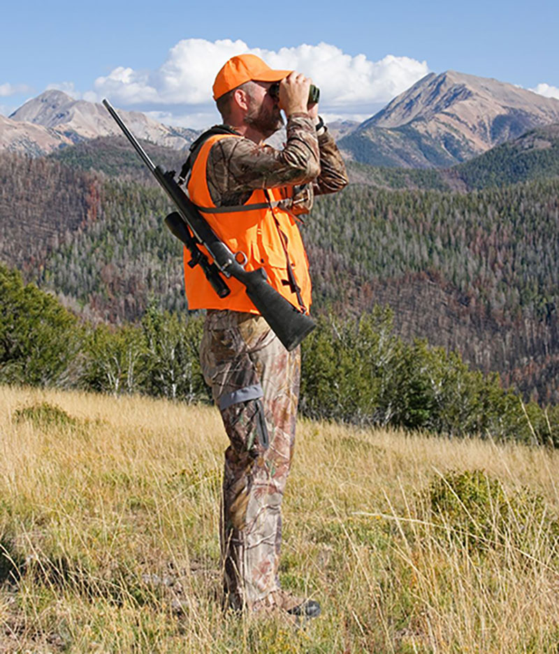 hunter in camouflage looking through binoculars