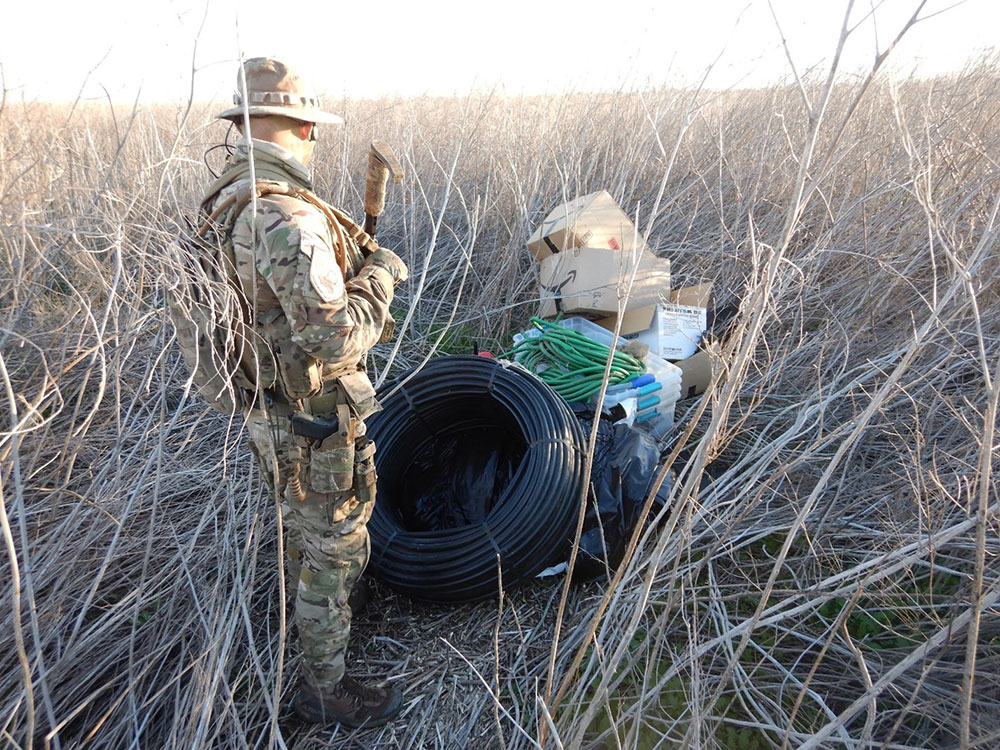 wildlife officers next to trash heap