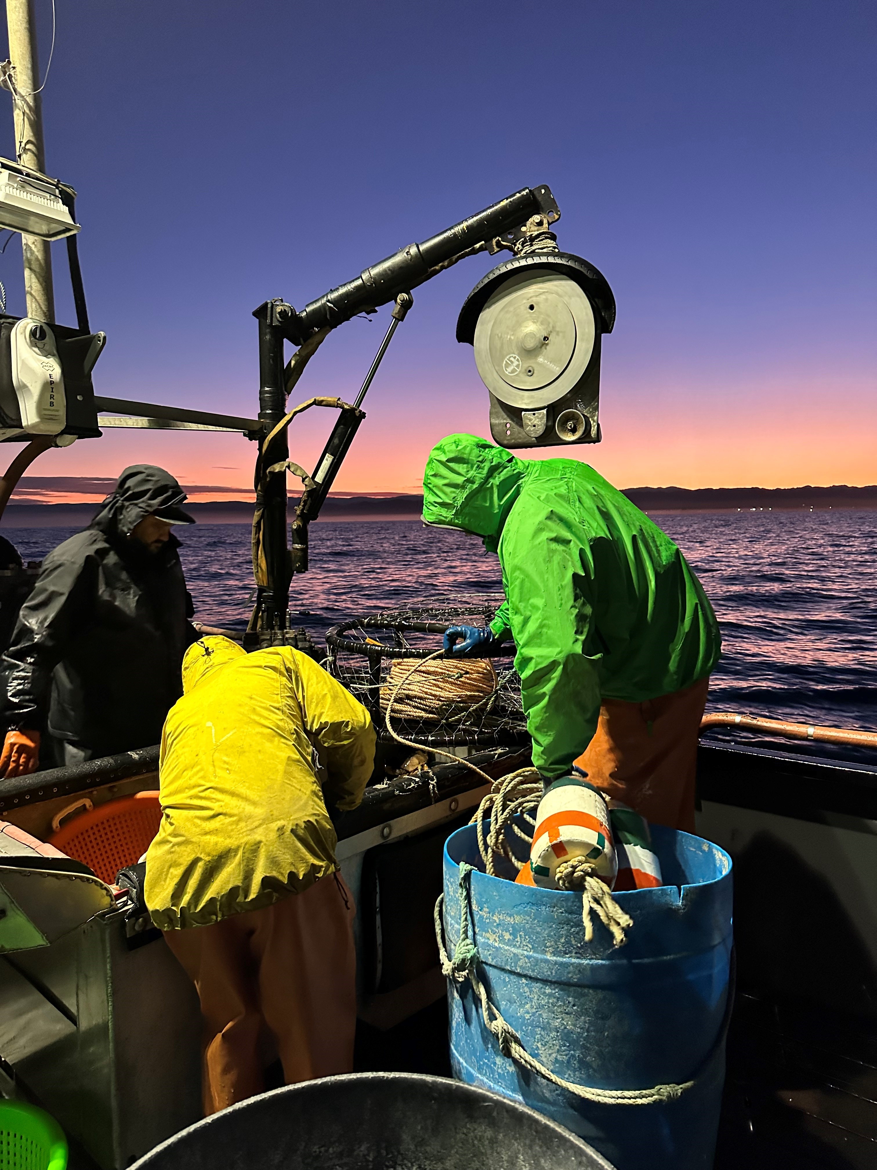 3 people on a boat at dusk