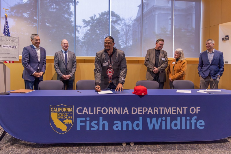 State officials, conservation leaders watch as Round Valley Indian Tribes President Joseph Parker signs a water rights agreement at the California Natural Resources Agency headquarters in Sacramento.