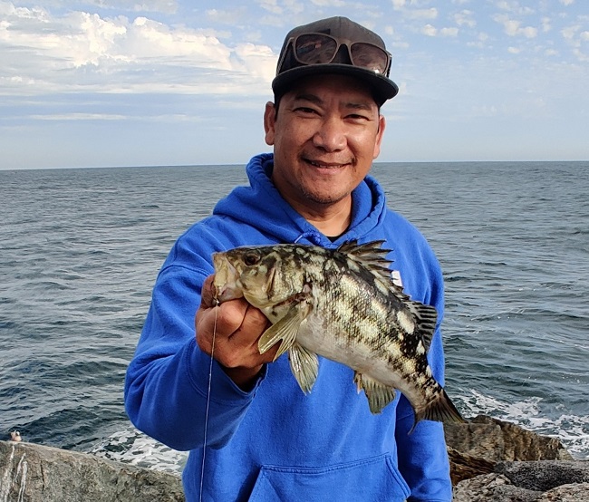 A saltwater angler shows off a calico bass caught from shore.