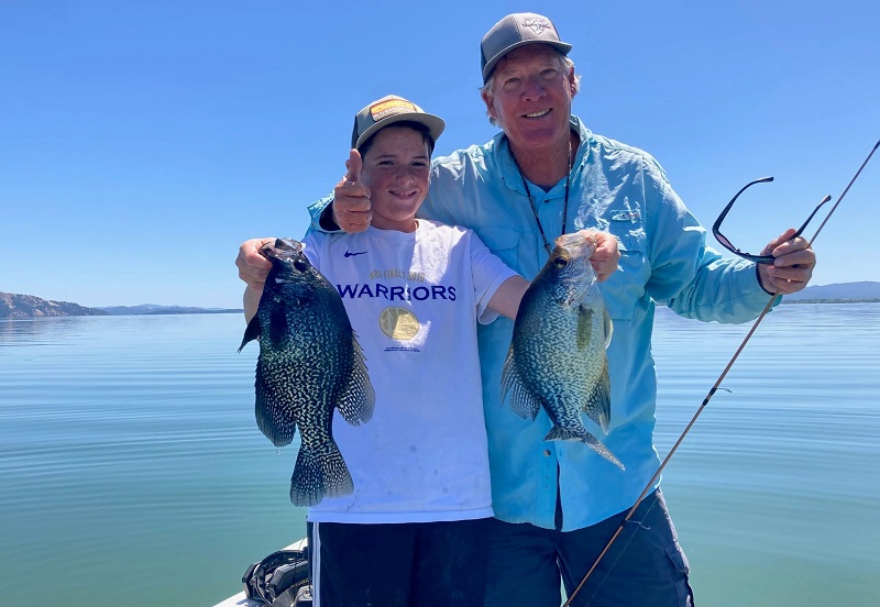 Two anglers show off their catches of two crappie aboard a boat on Clear Lake in Lake County, California