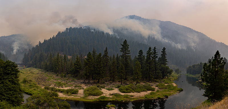 The Dixie Fire, burning a forested hillside along a river, already has claimed portions of Butte, Plumas, Tehama, Lassen and Shasta counties.