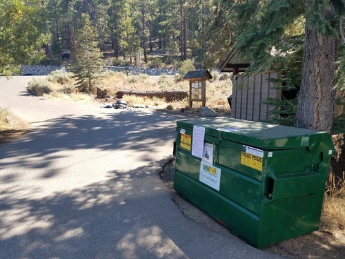 A properly secured green dumpster in the Lake Tahoe Basin -- locked and closed with no access to garbage for black bears.