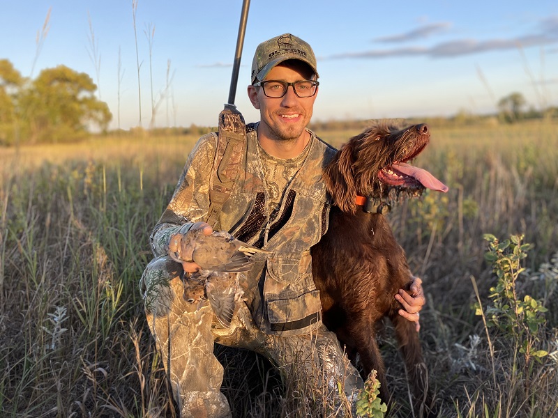 A hunter and his dog show off a mourning dove taken during dove season.