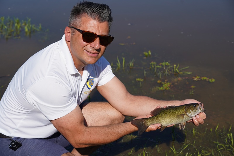 CDFW fisheries biologist Mike Mamola holds up a smallmouth bass caught at Gibson Ranch.