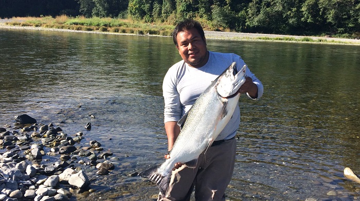 A lucky angler holds up  a large Chinook salmon caught on the Klamath River.