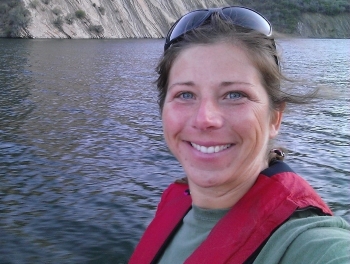 Jen smiling on a boat on a lake
