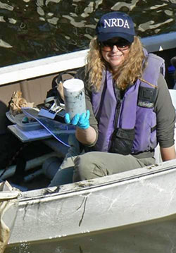 Scientist Montalvo posing with a sample collected at an oil spill in near Huntington Beach