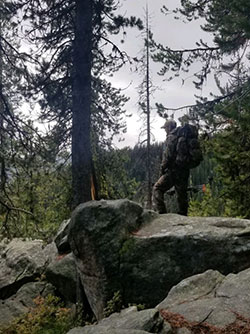 Carrothers is standing in the woods during an Elk hunt in Idaho
