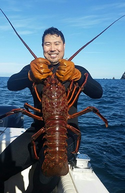 Kevin Kwak shows off an impressive spiny lobster he caught diving.