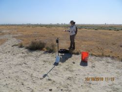 Scientist setting camera trap in field