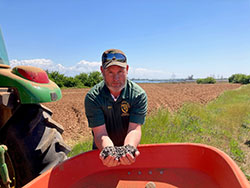 Scientist Brian Young holding soil in a field
