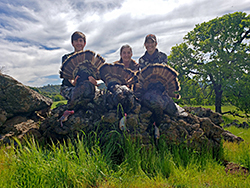 Shelly Blair with her children, Jesse and Amy, pose with the three tom turkeys they each harvested during a spring turkey hunt.