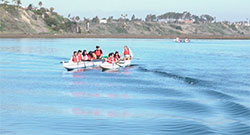 groups on people on two kayaks on the ocean in Newport Bay with mountains and blue sky