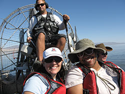 four scientist on a boat on a lake