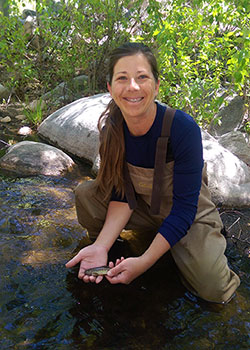 Biologist, Jen Hemmert holding a small fish