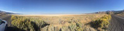 Panoramic view of dry grassland and blue sky.