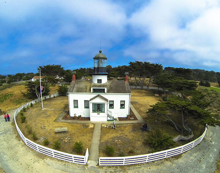 lighthouse surrounded by circular fence and cypress trees