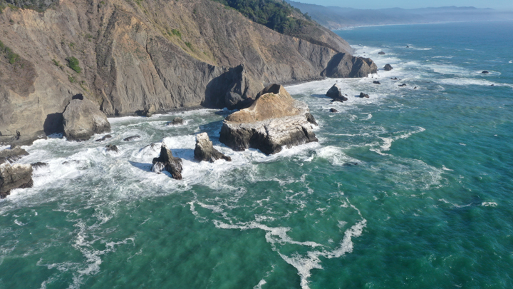 downward view of water crashing against steep rocks