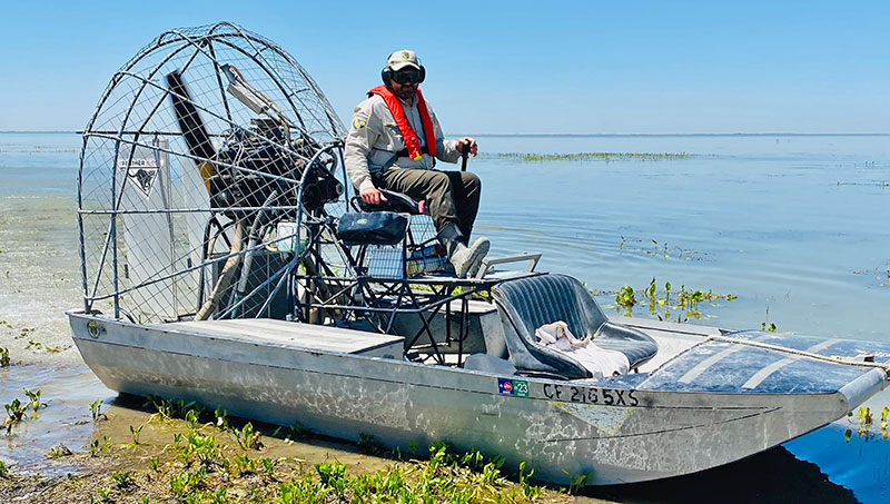 man upon airboat in shallow water
