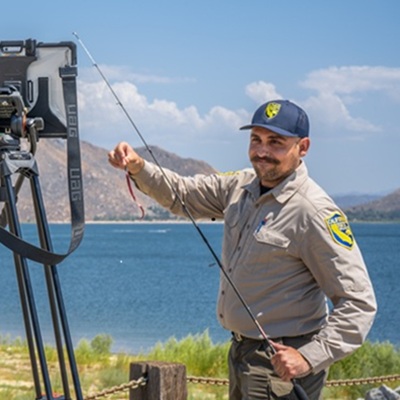 image of staff in uniform teaching next to a lake