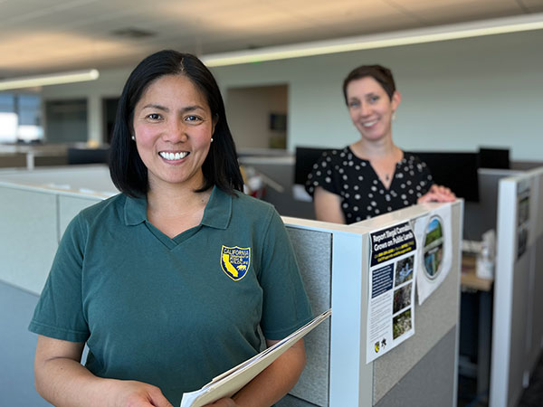 two women standing near office cubicles