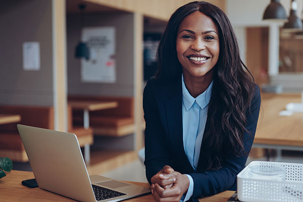 woman sitting by laptop in group work area