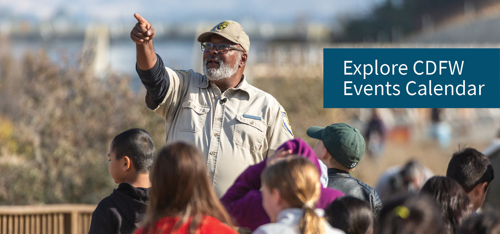 Explore CDFW Events Calendar - CDFW officer pointing in front of kids