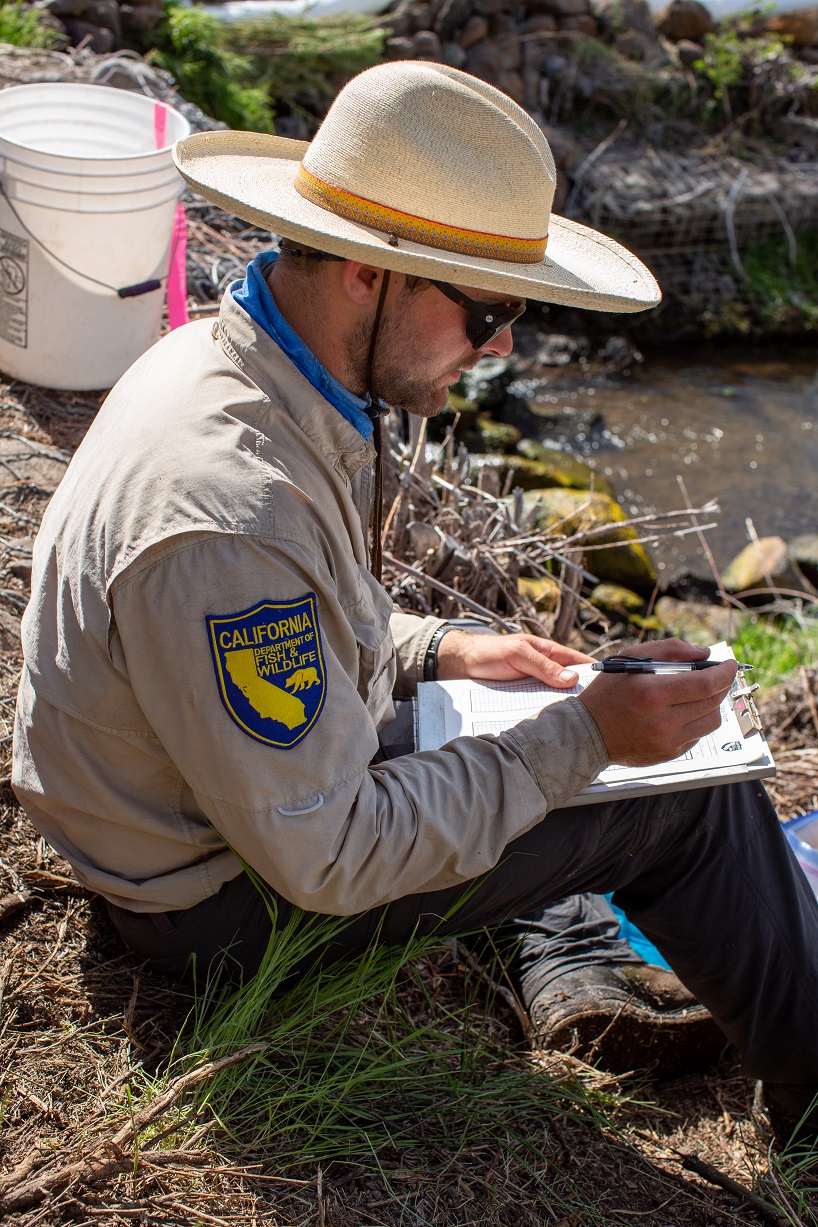 scientist recording data on a clipboard in the field