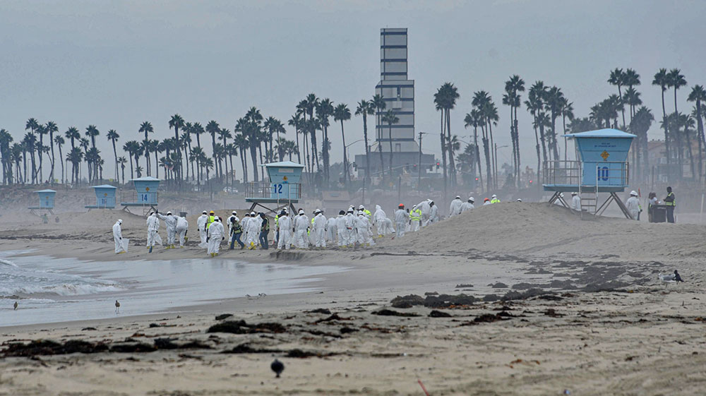 people in white jumpsuits on a misty beach