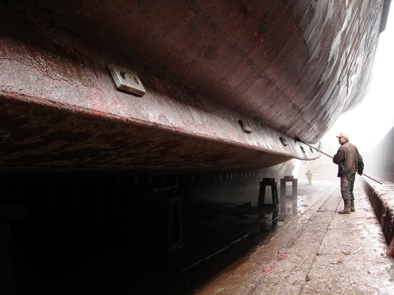 Ships hull getting cleaned in dry dock