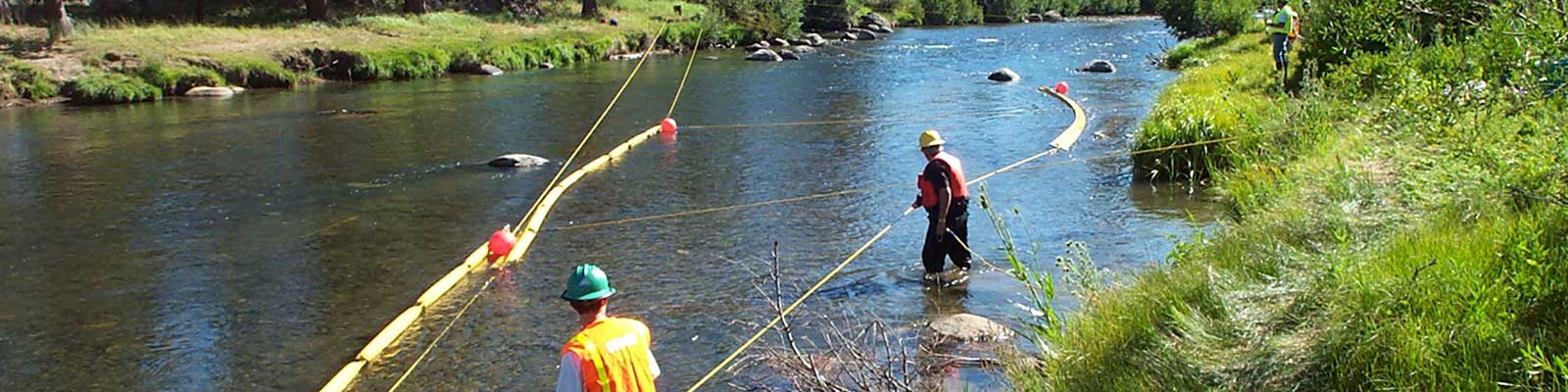 people extending booms on a river