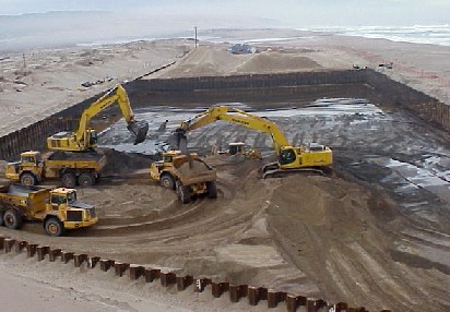 Trucks and tractors moving contaminated sand.