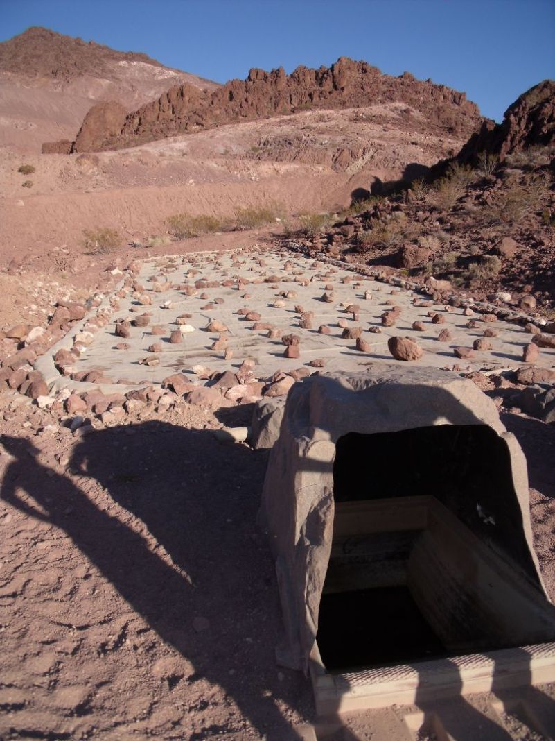 A rain mat where water collects is linked to a below-ground water tank. A fake rock covers an entrance to the tank that the sheep drink from.