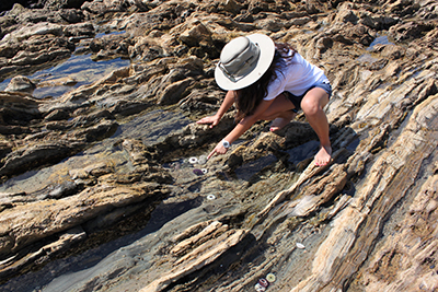 woman pointing at something in tide pool