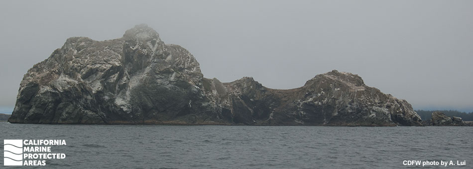 an unevenly shaped rocky island in the ocean